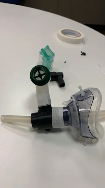 Versão impressa em preto do dispositivo montada na máscara da bolsa-válvula, com tubo de silicone