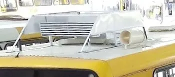 Duto impresso em 3D com pintura de proteção, com uma grade e uma saída cilíndrica, sobre o teto de um ônibus