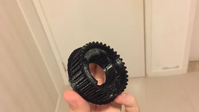Polia dentada em polímero preto segurada na mão